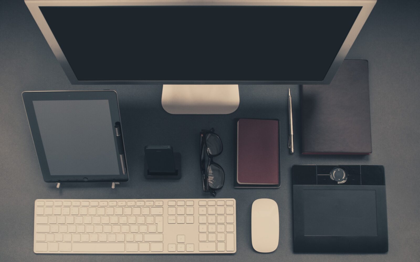 A computer desk with a keyboard, mouse and tablet.