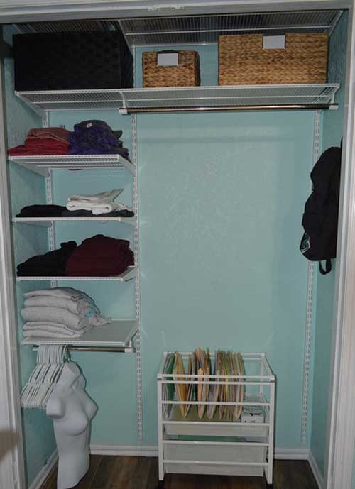 A closet with shelves and baskets for clothes.