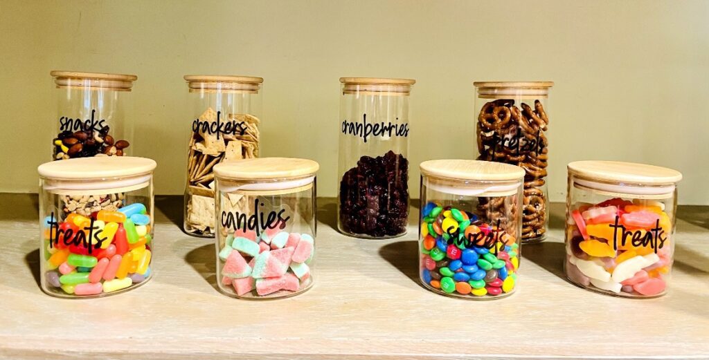 A table with several jars of different types of candies.