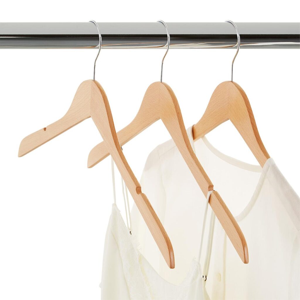Three wooden hangers hanging on a metal bar.