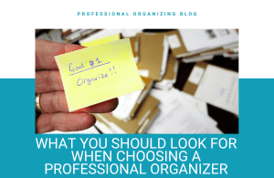 A person holding up a sticky note with an organized background.