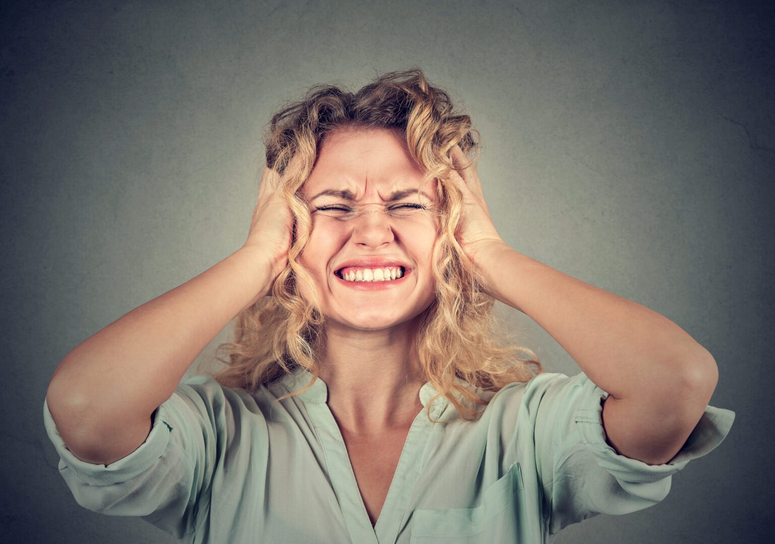 A woman holding her head with both hands.