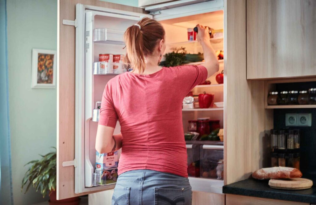 pretty-neat-edmond-ok-organizing-tips-for-thanksgiving-woman-cleaning-out-refrigerator-comfortable-move-management-specialists