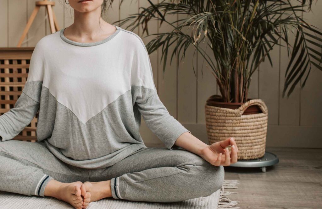 move-management-specialists-nichols-hills-ok-non-physical-ways-to-organize-woman-meditating-in-room-comfortable-clothes-potted-plant-comfortable