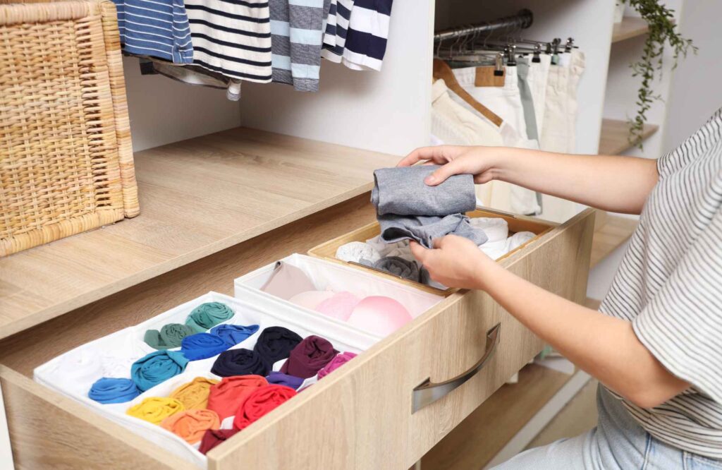 professional-home-organizers-gaillardia-country-club-ok-closet-organization-tips-woman-folding-clothing-in-drawer-in-closet-decluttering