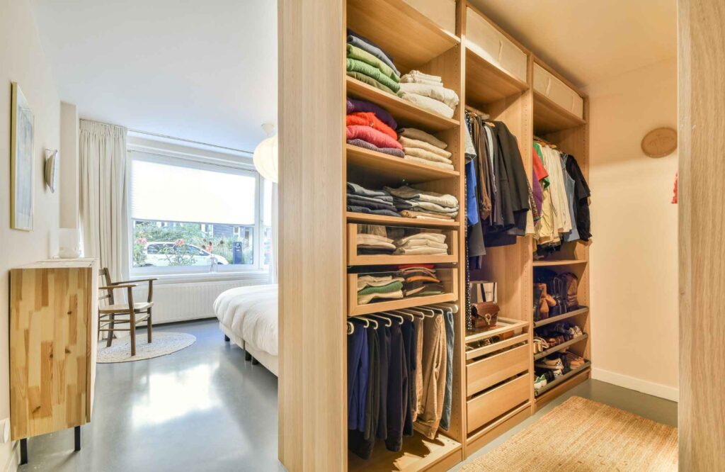 professional-home-organizing-oklahoma-city-ok-how-organizing-transforms-daily-life-walk-in-closet-neatly-organized-with-view-of-bedroom-comfortable