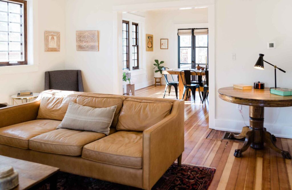 pretty-neat-edmond-ok-daily-routines-to-stay-organized-living-room-with-leather-sofa-round-table-view-into-dining-room-warm-colors-well-being