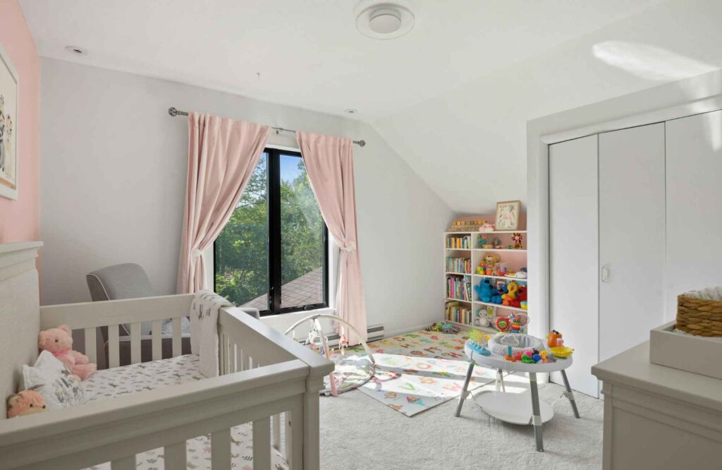 professional-home-organizer-oklahoma-city-ok-organizing-kids-bedrooms-babys-room-with-white-crib-pink-drapes-play-area-with-bookshelf-calm-move-management