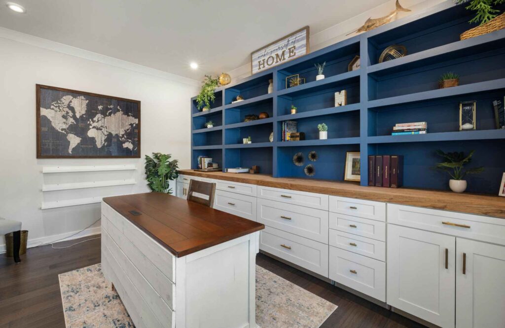 pretty-neat-edmond-ok-letting-go-of-belongings-home-office-with-shiplap-desk-built-in cabinets-dark-blue-shelves-world-map-art-reduce-stress