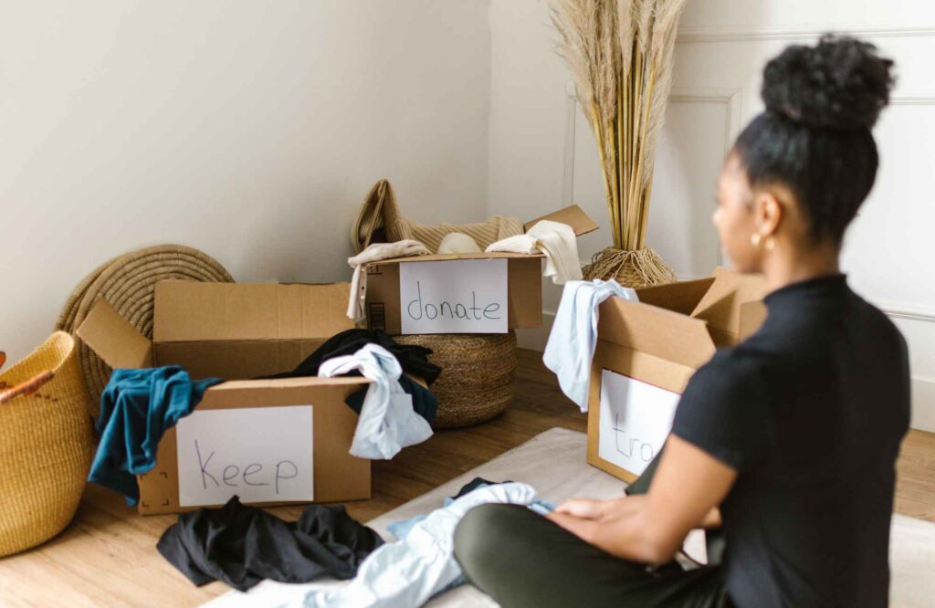 pretty-neat-oklahoma-city-ok-summer-decluttering-woman-sitting-on-floor-sorting-items-into-donate-boxes-calm-move-management-specialists