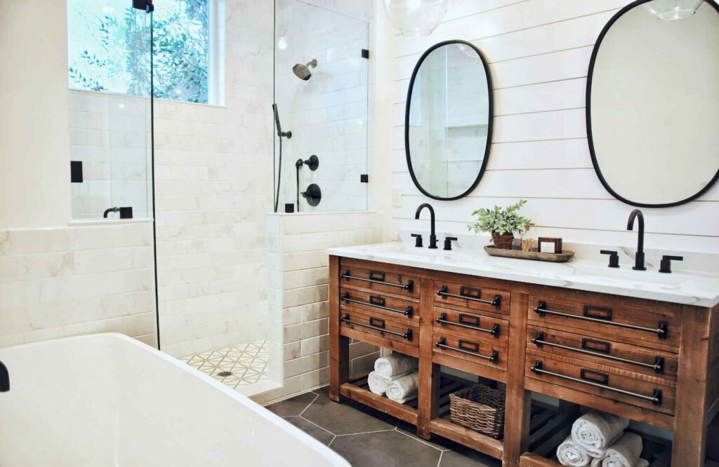 professional-home-organizing-edmond-ok-shared-bathroom-organizing-wood-vanity-with-drawers-and-open-shelves-round-mirrors-white-tile-reduce-stress