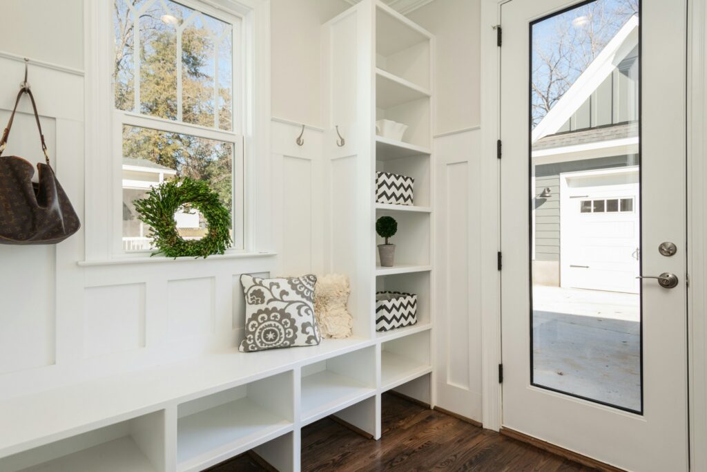 pretty-neat-edmond-ok-mudroom-organization-tips-entryway-with-white-built-in-shelves-and-bench-with-pillows-coat-hooks-reduce-stress